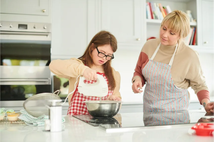 mom and daughter baking a cake together
