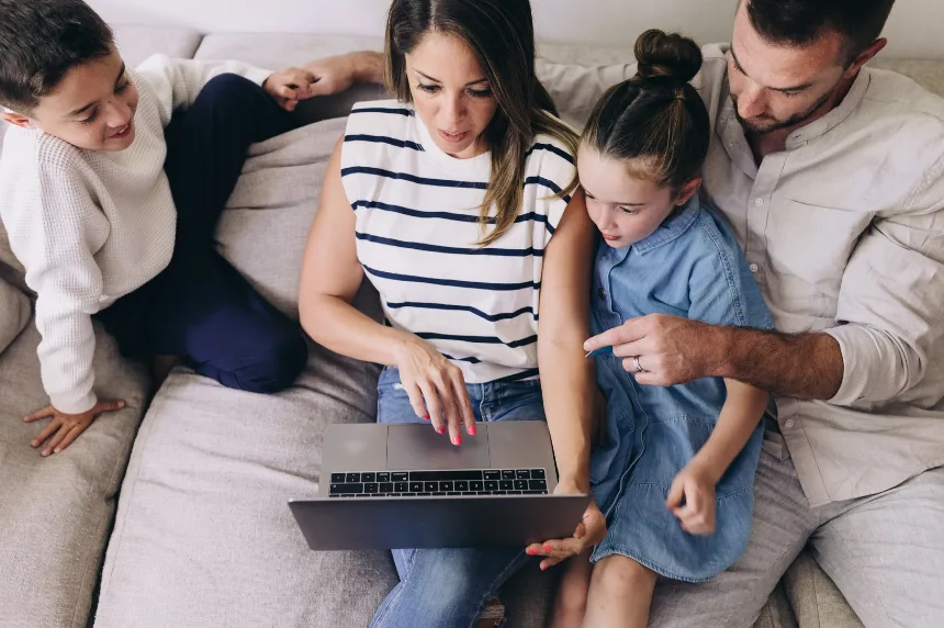 A family researching and learning together on a laptop