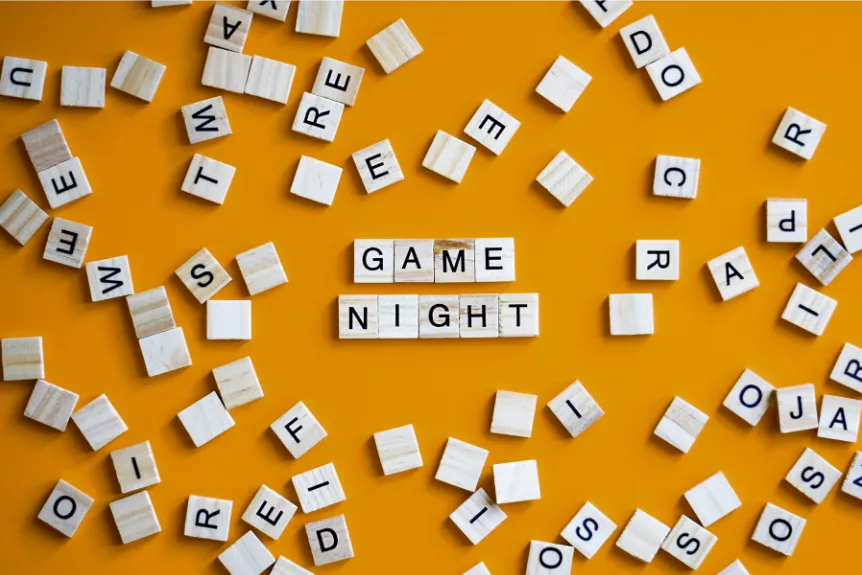 scrabble style tiles on a mustard yellow background that spell game night